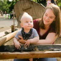 Kleinkind spielt auf dem Wasserspielplatz