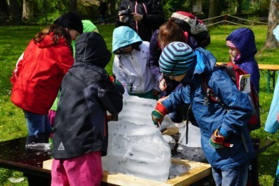 Kinder picken sich Figuren aus einem Eisblock