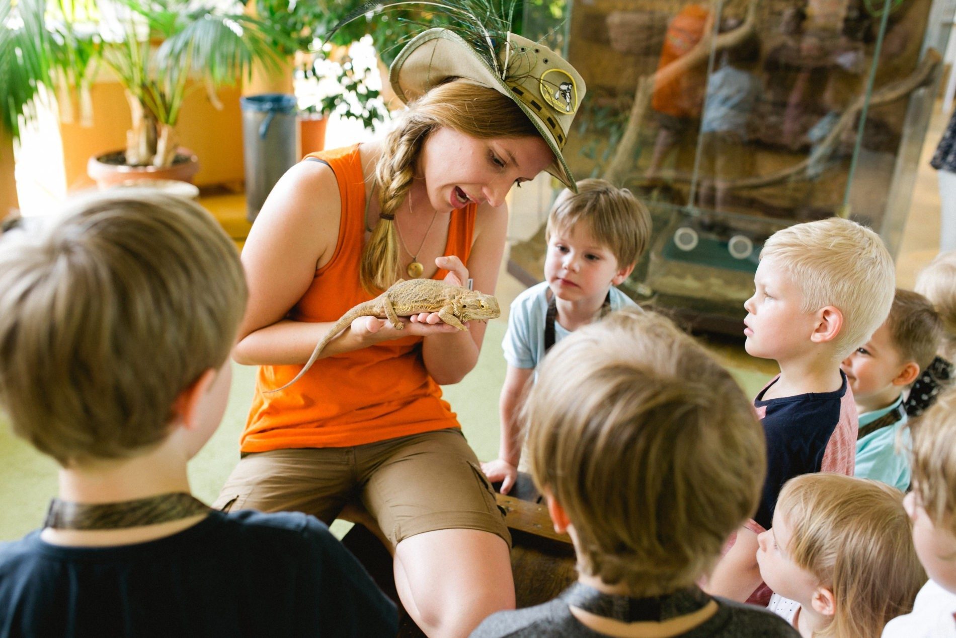 Ein Zooscout zeigt den Kindern bei einer Zootour Reptilien